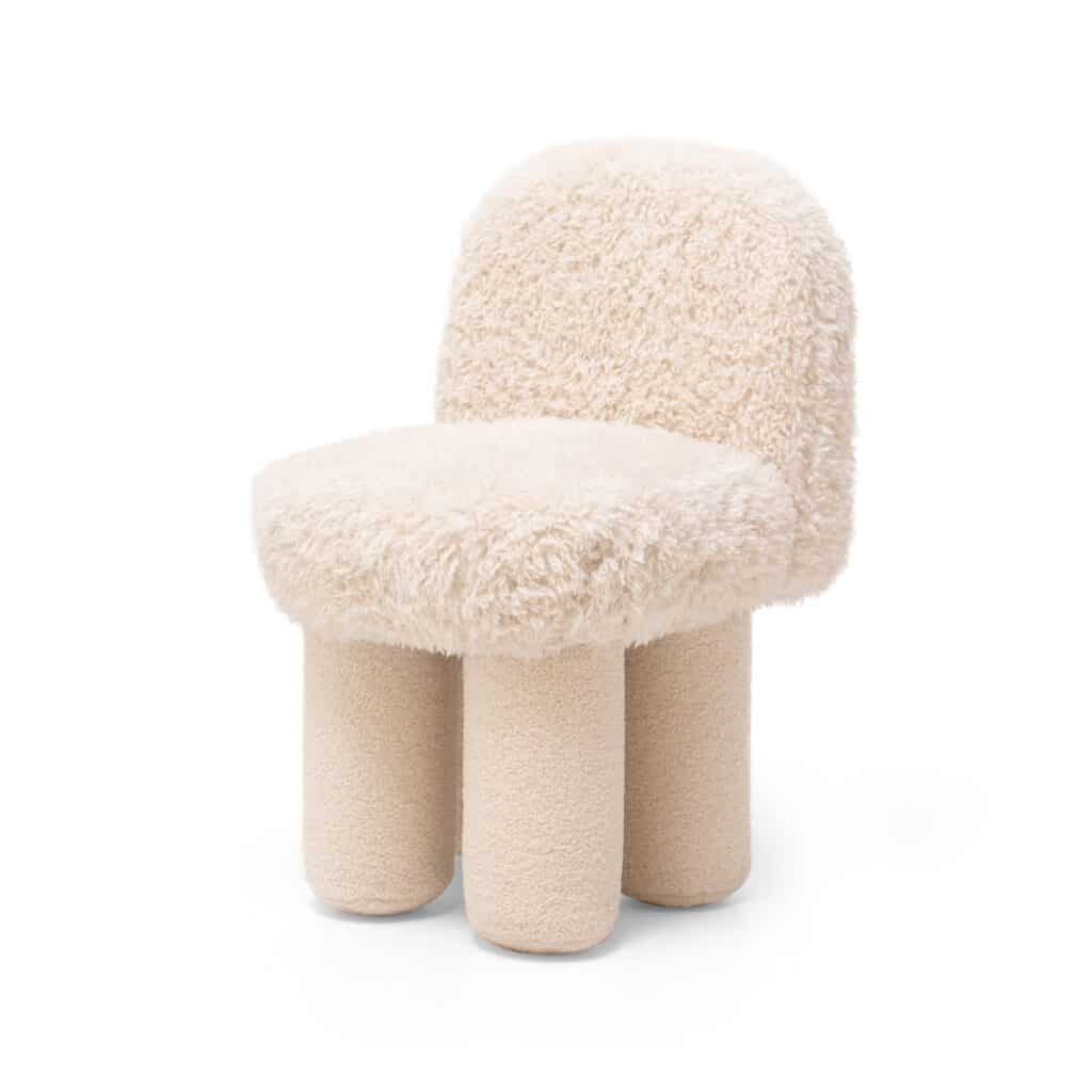 Tabouret design en bouclé crème avec dossier et assise moelleuse. L'assise repose sur trois pieds épais et arrondis.