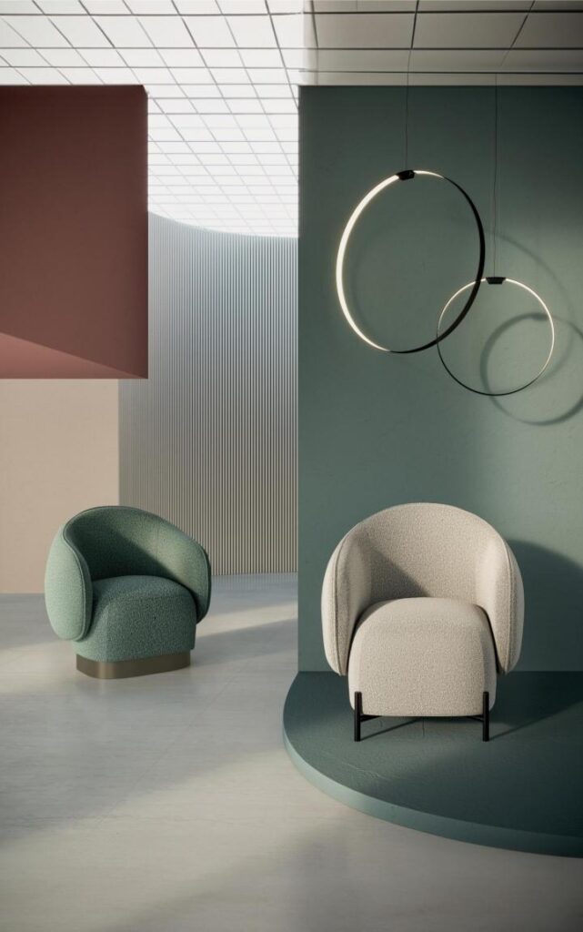Deux fauteuils design rembourrés, vert mousse et crème, dans un intérieur contemporain. Murs terracotta, vert sauge, et luminaires circulaires.