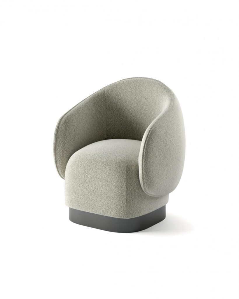 Fauteuil design moderne en tissu bouclé beige-gris, caractérisé par une forme enveloppante et une base cylindrique foncée.